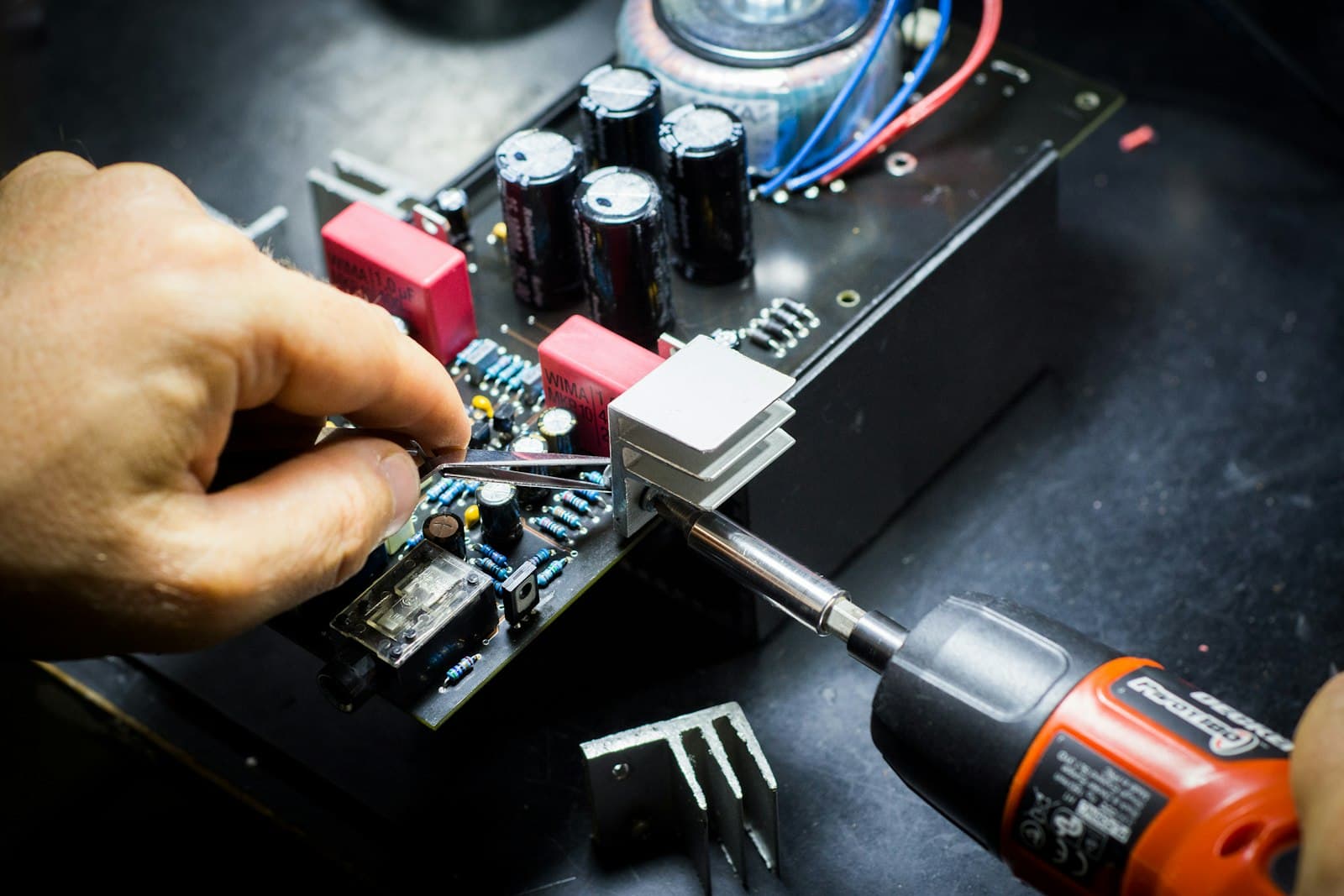 Técnico revisando la placa de un notebook abierto sobre el banco de trabajo.